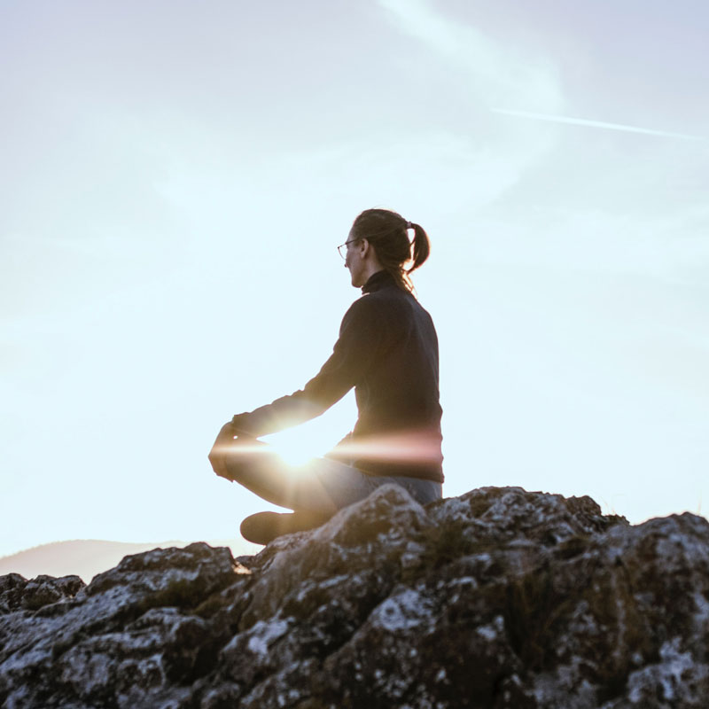 Woman who is able to relax on scenic rocks because she purchased a GoReady cruise plan.