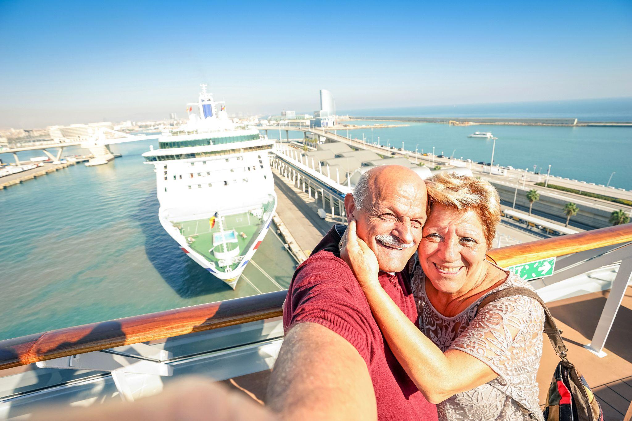 Senior happy couple taking selfie on cruise ship with harbor background Senior happy couple taking selfie on cruise ship with harbor background